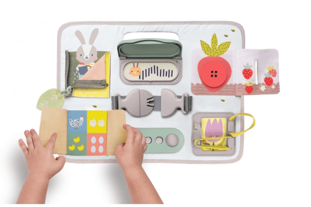 Activity Buckles Board by Taf Toys, 18 months and up, busy board for toddlers, Zipper, Peek-a-boo Bunny, Velcro Straps, Buckle, Pull Snap Strap, Laces, XL Button, Snap Cover, Numbers and counting, best toddler toys, fine motor skills, practical life skills, The Montessori Room, Toronto, Ontario, Canada.